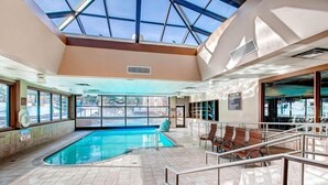 An indoor swimming pool with a glass ceiling, seating areas, and a view of the outside. - 1 Bedroom Ski in, Ski out Mountain Vacation Rental Located Next to Historic Main Street in Downtown Breckenridge (Breckenridge)