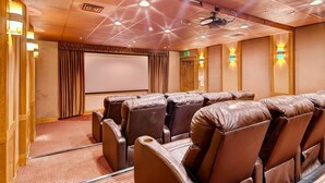 A theater room with leather reclining seats, a large screen, and ceiling lights. - Perfectly Placed 2 Bedroom Vacation Rental in Historic Downtown Breckenridge with Access to Hot Tub and Pool (Breckenridge)