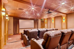 A theater room with leather reclining seats, a large screen, and ceiling lights. - Perfectly Placed 2 Bedroom Vacation Rental in Historic Downtown Breckenridge with Access to Hot Tub and Pool (Breckenridge)