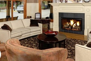 A cozy living room with a fireplace, a sofa, a coffee table, and a patterned rug. - Perfectly Placed 2 Bedroom Vacation Rental in Historic Downtown Breckenridge with Access to Hot Tub and Pool (Breckenridge)