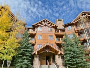 A multi-story lodge with a central entrance, wooden balconies, and stone pillars. - Luxury 1 Bedroom Mountain Vacation Rental in Breckenridge With Access to a Hot Tub and Heated Garage Parking (Breckenridge)