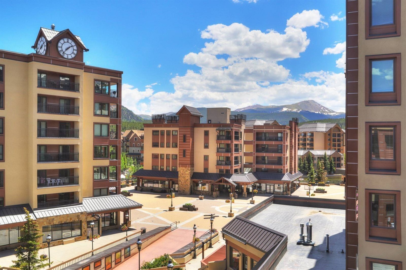 A multi-story hotel with a central courtyard, balconies, and a clock tower.