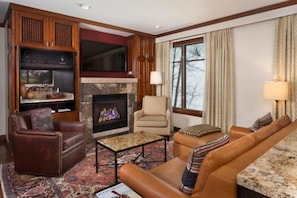 A cozy living room with a fireplace, leather sofas, and a television. - Aspen Highlands 2 Bedroom Residence at the Ritz-Carlton (Aspen)