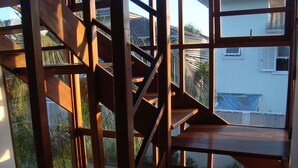 A wooden staircase with a view of a house and palm trees. - 4 suites WITH AIR CONDITIONING + 1 bedroom-living room with bathroom 2 refrigerators barbecue garden terrace TV DVD YT (São Sebastião)