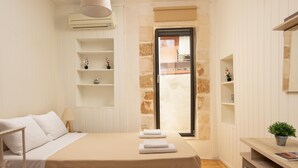A bedroom with a bed, bedside tables, a desk, and a window with a view. - Evans House II One Bedroom Maisonette (Chania)
