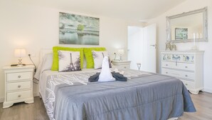 A bedroom with a bed, a nightstand, a dresser, a mirror, and a painting on the wall. - FINCA MIRALLES - Villa with private pool in Búger. Free WiFi (Búger)