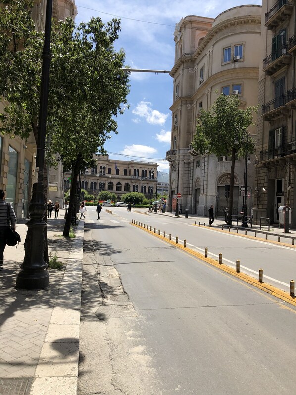A street with buildings, trees, and pedestrians.