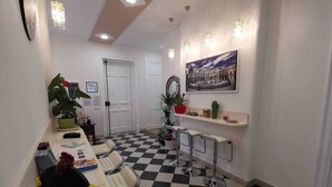 Un salón de conferencias con piso a cuadros, paredes blancas y un cuadro de un paisaje urbano.
