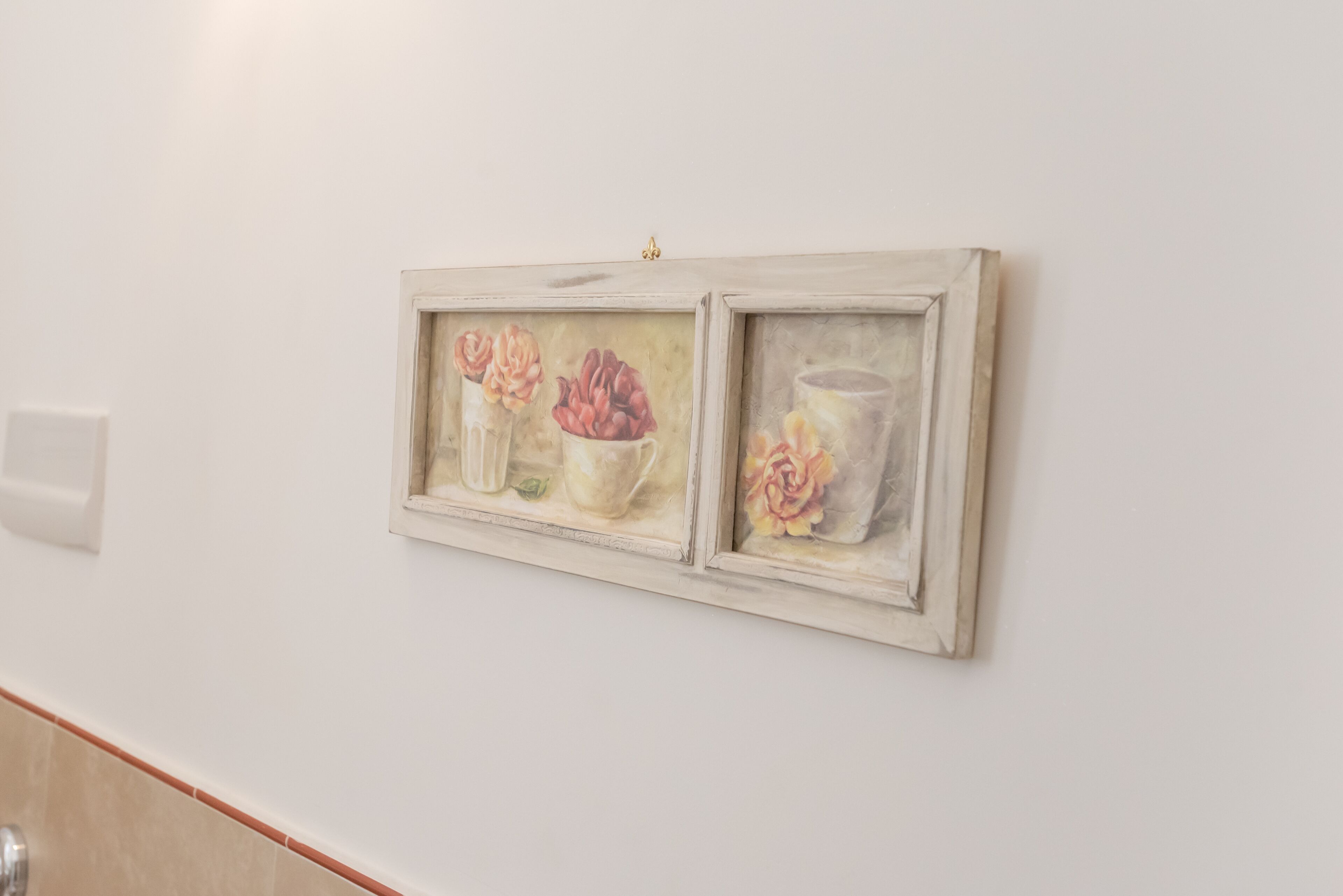 A wall-mounted artwork depicting floral arrangements.