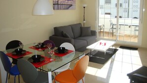 A dining area with a glass table, red placemats, and modern chairs. - Residencial Duquesa 2049  Manilva Beach (Manilva)