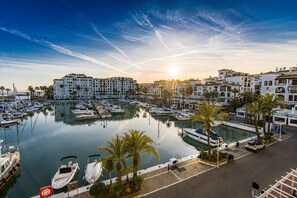 Un port de plaisance avec des bateaux, un espace de stationnement et des bâtiments dotés de balcons.