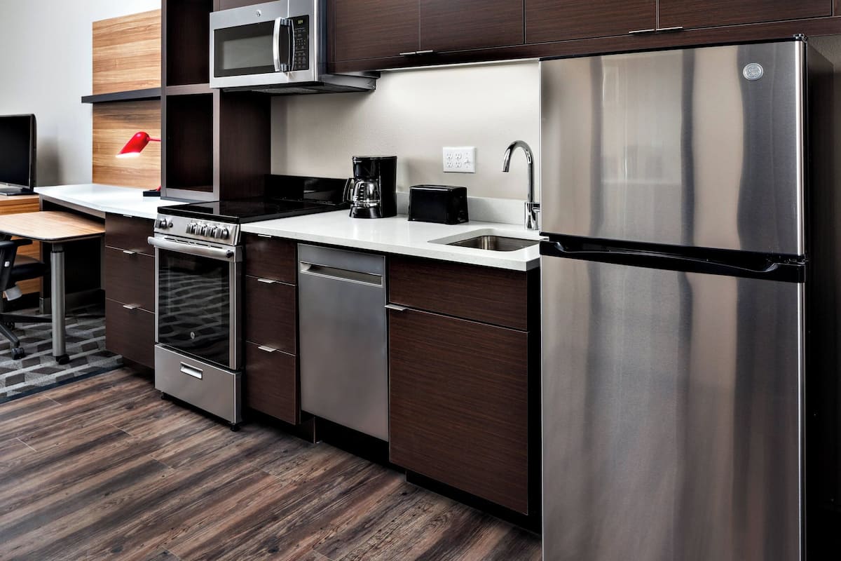 A modern kitchen with stainless steel appliances, a microwave, a coffee maker, and a toaster.
