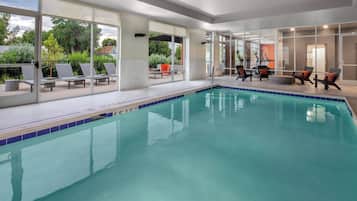 Relax by the pool surrounded by lush greenery and a serene atmosphere.