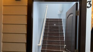 Eine Holztreppe führt zu einer Tür mit der Nummer 3.