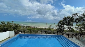 Une piscine avec vue sur l’océan et la plage.