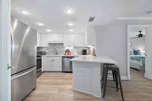 A modern kitchen with white cabinets, stainless steel appliances, and a central island. - ORANGE BEACH RETREAT, GREAT VIEW OF THE PASS, GREAT AMENITIES, GREAT FOR FAMILY (Orange Beach)