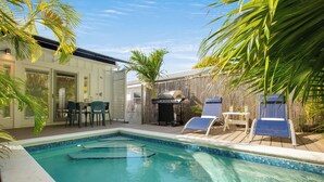 A backyard with a swimming pool, a barbecue area, and outdoor seating. - HEMINGWAY'S HIDEOUT ~ Historic Old Town Cottage with Pool! (Key West)