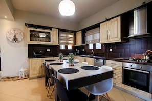 Enjoy cooking in this kitchen with a central island, stainless steel range hood, and wooden cabinets.