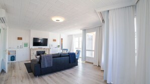 A modern living room with a sofa, TV, and fireplace. - Beautiful apartment for 6 people with A/C, WIFI, TV and patio (Binissalem)