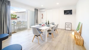 A modern dining area with a white table, grey chairs, and a wooden floor. - Beautiful apartment for 6 people with A/C, WIFI, TV and patio (Binissalem)