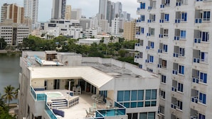 Ein Hochhaus mit mehreren Balkonen und einer Dachterrasse mit Gartenmöbeln.
