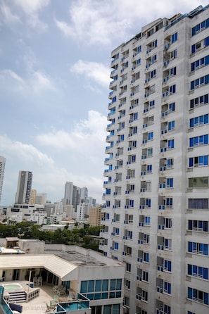A high-rise building with multiple balconies and a rooftop pool area. - APARTA STUDIO PLAYA MAR SUITE 5  (Cartagena)