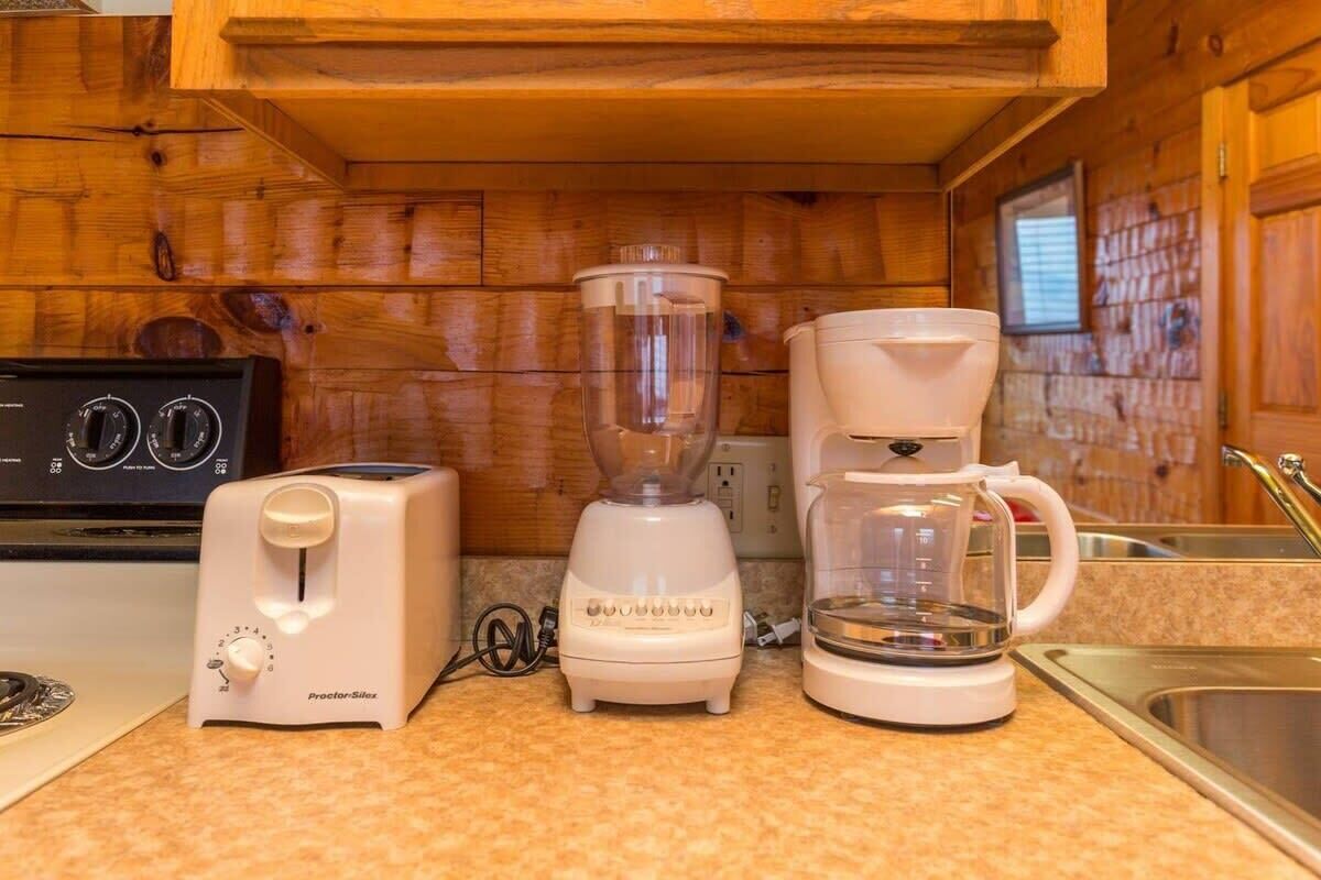 Une petite cuisine équipée d’un grille-pain, d’un mixeur et d’une machine à café.