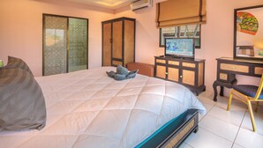 Une chambre à coucher avec un lit, un bureau, une chaise et un téléviseur.