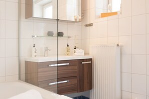 Bathtub, hair dryer, towels, shampoo