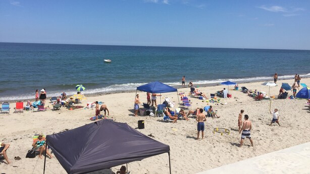 A beach with people sunbathing, umbrellas, and beach chairs. - "THE PLACE AT SUNRISE BEACH" (Marshfield)