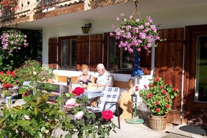 A patio with a table, chairs, and potted plants. - Guesthouse Schober - Jodlhof, Kreuth-Scharling - Apartment (Kreuth)