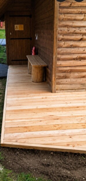 A wooden cabin with a bench and a door.