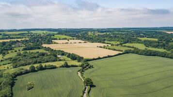 An aerial view of a rural landscape with fields, a winding road, and scattered buildings.