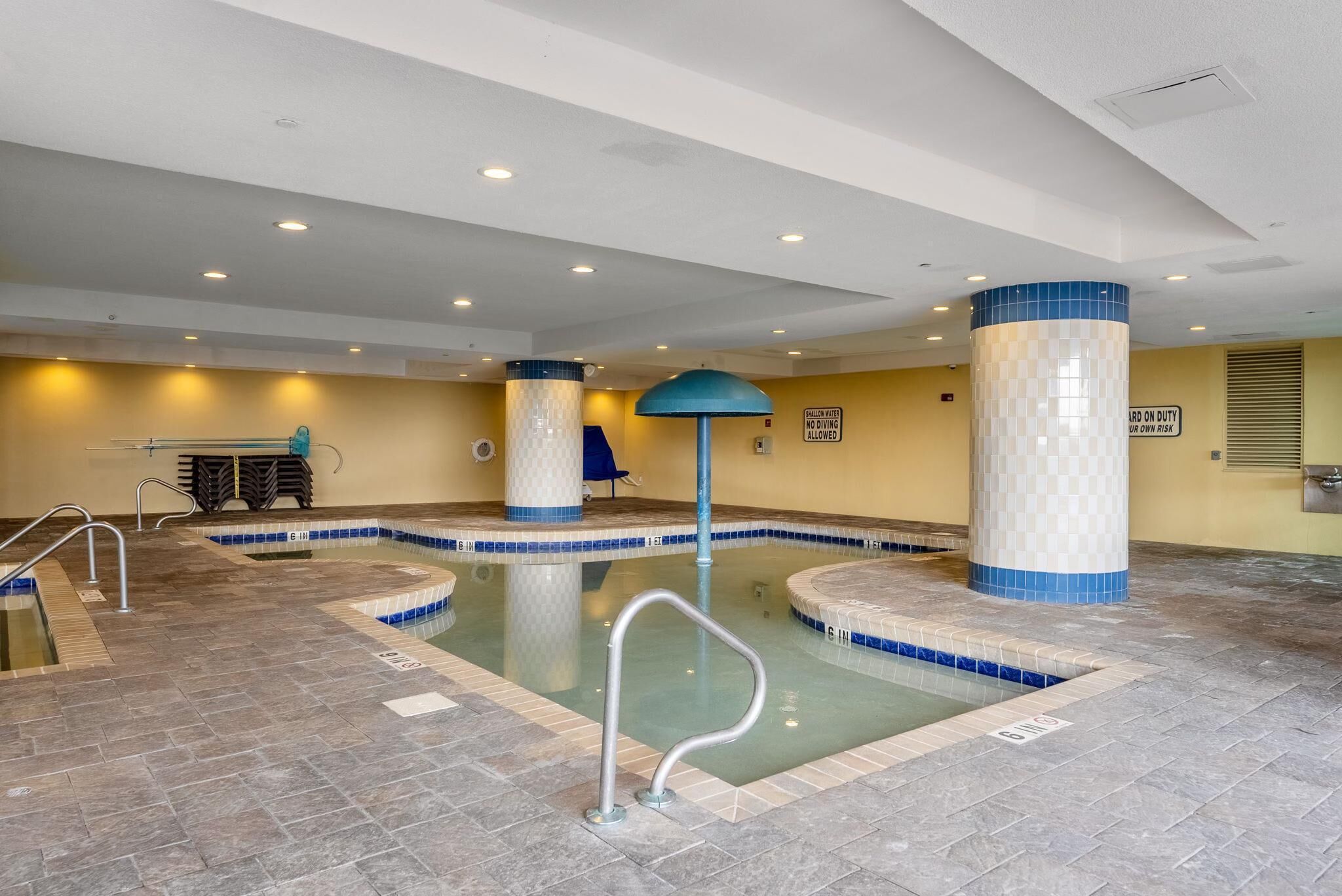 Una piscina interior con paredes de azulejos y un diseño azul y blanco a cuadros.
