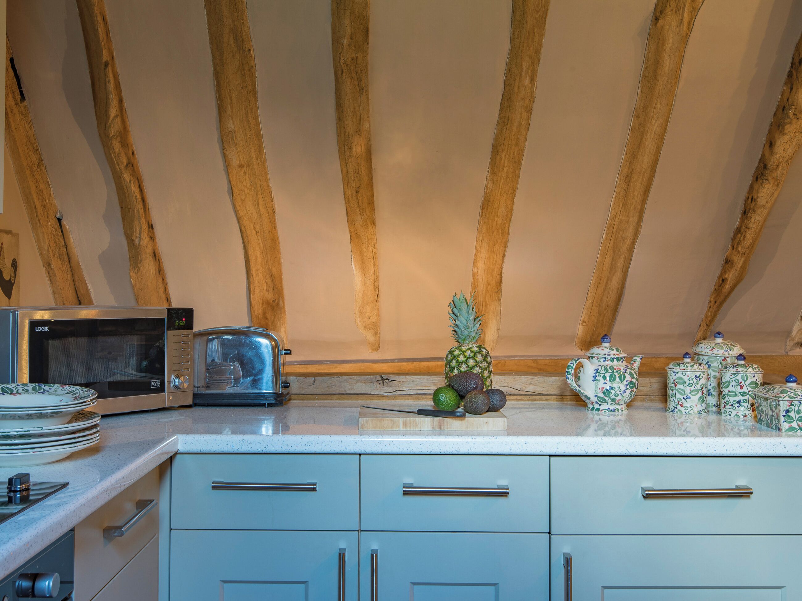 Una cocina con microondas, tostadora y objetos decorativos en la encimera.