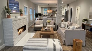 Una sala de estar moderna con chimenea, sofás y una mesa de centro.