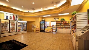 Ein gut beleuchteter Convenience Store mit Kühlregalen, Snackreihen und einer Selbstbedienungsgetränkemaschine.