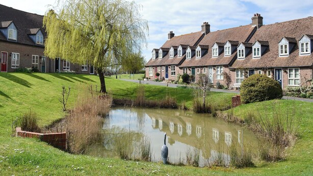 A row of traditional brick houses with a pond in the foreground. - 2 bedroom accommodation in Binfield, near Newport (Binfield, near Newport)