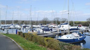 A marina with multiple boats docked, a grassy area, and a clear sky. - 2 bedroom accommodation in Binfield, near Newport (Binfield, near Newport)