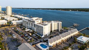 Un hotel frente al mar con varias edificaciones, un puerto deportivo y una piscina.