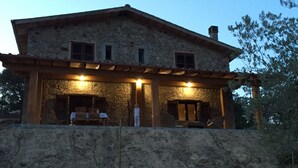 A stone building with a covered patio and a small outdoor seating area. - Agriturismo Campo al Crognolo. (Sassofortino)