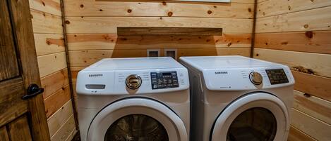 Un lavadero con dos lavadoras Samsung y un letrero que dice 'WASH & DRY'.