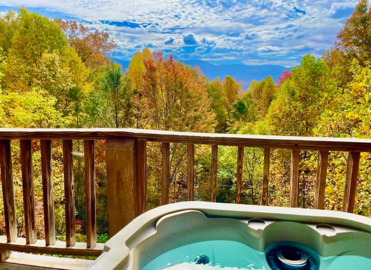 Ein Whirlpool auf einer Holterrasse mit Blick auf Herbstbäume.