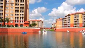 A waterfront hotel with multiple buildings, a calm river, and boats. - BEAUTIFUL RESORT STUDIO NEAR DISNEY (Kissimmee)
