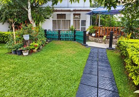 A well-maintained garden with a paved pathway leading to a covered seating area.
