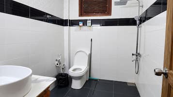 Casa de banho com sanita, bidé e chuveiro.