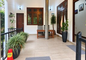 A spacious hallway with a wooden bench, potted plants, and a large window with a view of greenery.