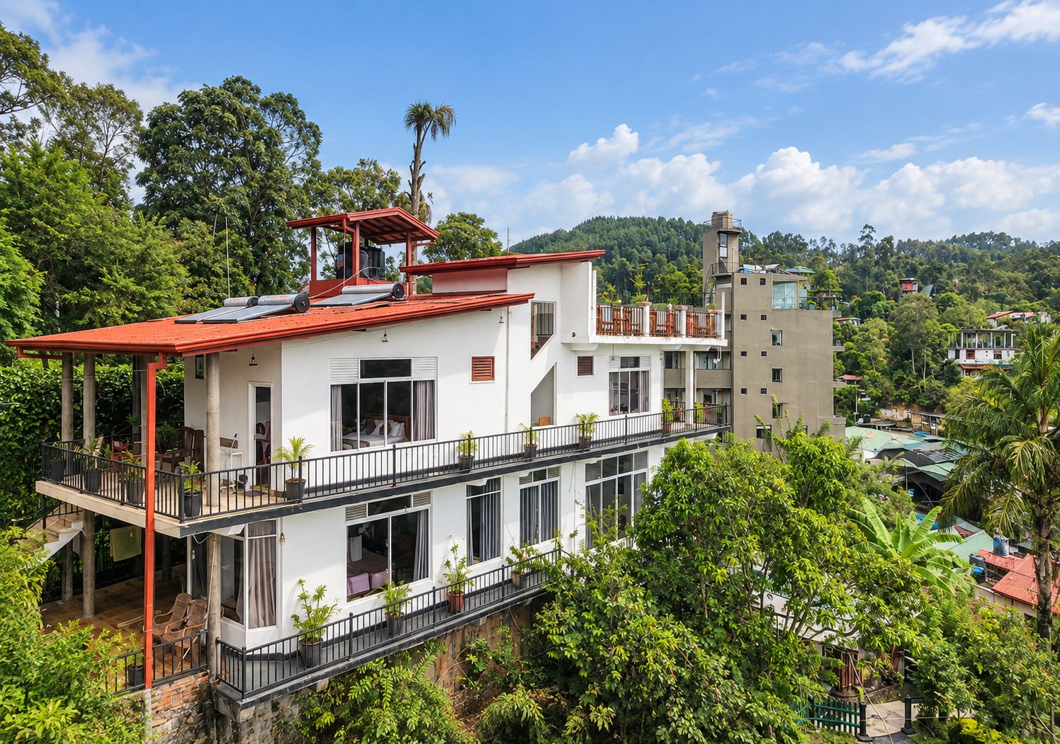 Edifício com várias andares e sacadas, rodeado por vegetação exuberante.