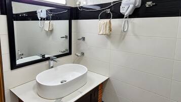 A bathroom with a white sink, a mirror, a hairdryer, and a towel rack.