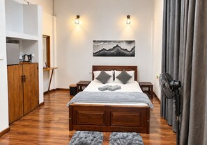 Une chambre à coucher avec un lit en bois, deux tables de chevet, une œuvre d’art accrochée au mur et un rideau gris.